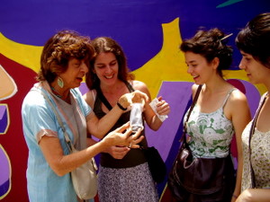 Dr. Mabel Bianco shows a female condom to three young women on a street in Buenos Aires.  - Juan Moseinco/IPS 