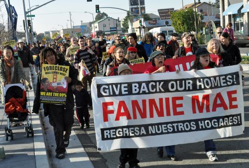 People march through West Oakland to the foreclosed home now owned by Fannie Mae that will be occupied as a community centre. - Judith Scherr/IPS