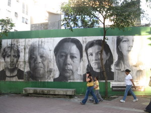 Faces of mothers whose children were killed peer out from walls in Caracas.  - Fidel Márquez /IPS  