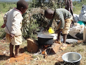 Victor Muruga (r) and his three-year-old brother Ian Kimani (l) prepare lunch from their camp at  Mumoi farm. - Peter Kahare/IPS