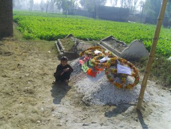 Slain Pakistani soldier Najibullah Khan's younger brother keeps vigil at his grave. - Ashfaq Yusufzai/IPS