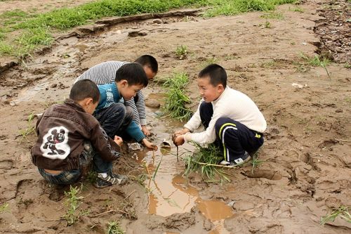 A group of Chinese boys plays in the mud. By 2013, one in 10 Chinese men of marriageable age will lack a female counterpart. / Credit:Jimmiehomeschoolmom/CC BY 2.0