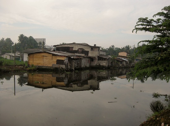 In some parts of Colombo, informal housing structures, or slums, are built right on waterways.  -  Amantha Perera/IPS