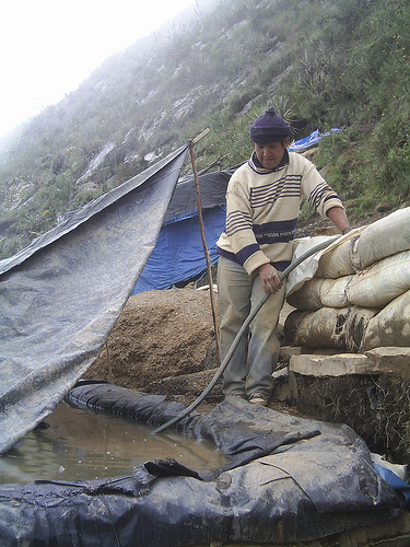 Small-scale miner next to cyanide leaching pit in Peru. - Milagros Salazar/IPS