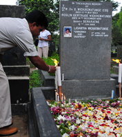 A colleague lights candles at the grave of assassinated editor Lasantha Wickrematunge. / Credit:Amantha Perera/IPS