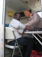 Registered nurse George du Plessis takes a patient's blood pressure in the mobile clinic. - Servaas van den Bosch/IPS
