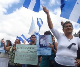 Hondurans hold up photos of missing loved ones.  - Danilo Valladares/IPS 