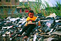 Migrant child from Hunan province sits atop one of countless piles of unrecyclable computer waste imported from around the world. Guiyu, China. / Credit:� Basel Action Network