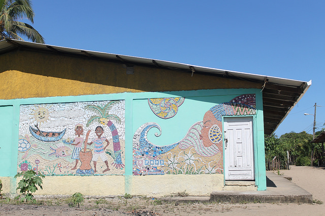 The mural of scraps of plastic and other recyclable materials made on the community centre wall by the people of Santa Rosa de Aguán to celebrate their way of life and the beauty of Garífuna women, and remind the town of the need to mitigate climate change. Credit: Thelma Mejía/IPS
