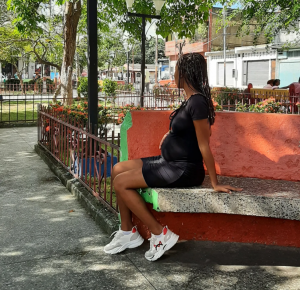 A pregnant teenage girl sits in a Caracas plaza. Teenage pregnancy often [...] <a class=