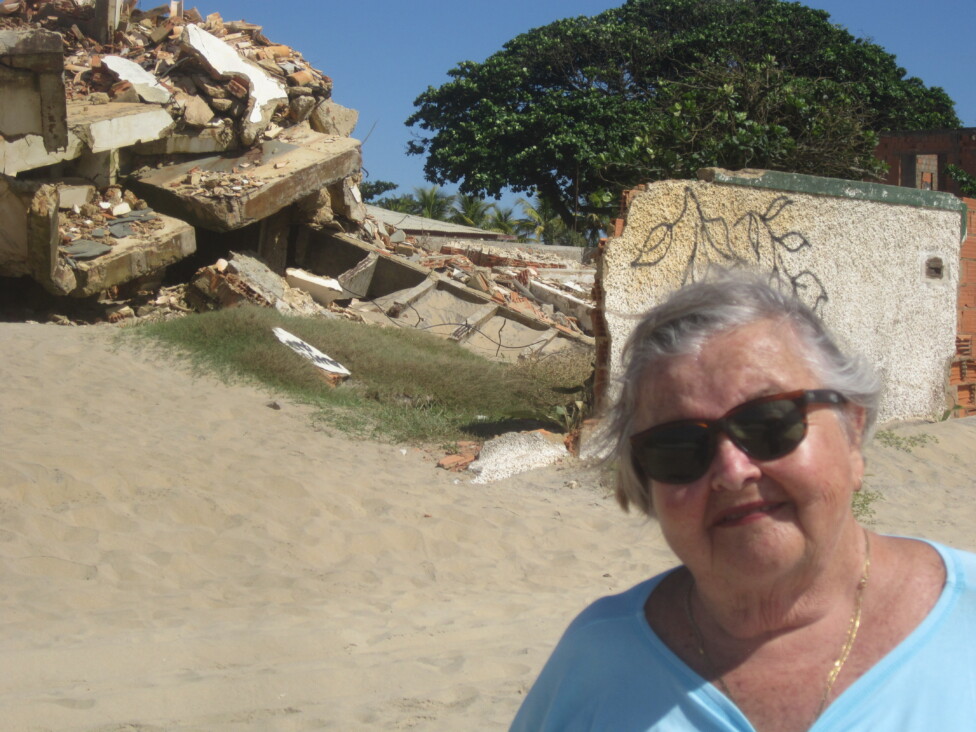 Sonia Ferreira stands in front of what was left of her home, which she decided to demolish in 2022, after coastal erosion knocked down its outer walls and washed out the sandy base, leaving just columns. CREDIT: Mario Osava / IPS