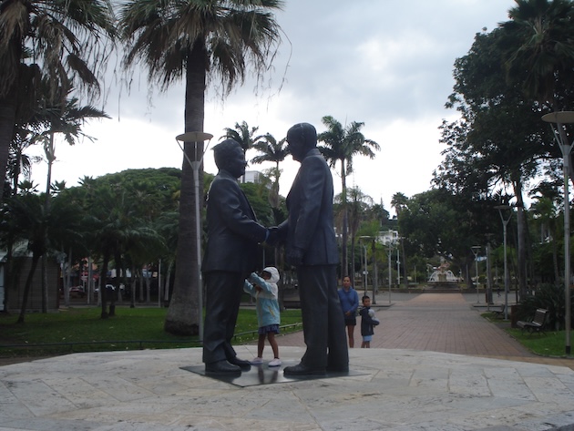 n Noumea's city park, a young child stands between the statues of Pro-France politician, Jacques Lafleur, and Pro-Independence Kanak leader, Jean-Marie Tjibaou, performing a handshake at the signing of the 1988 Matignon Accords in New Caledonia. Credit: Catherine Wilson/IPS