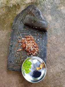 Green chillies, salt and ants on a stone mortar pestle depicts [...] <a class=