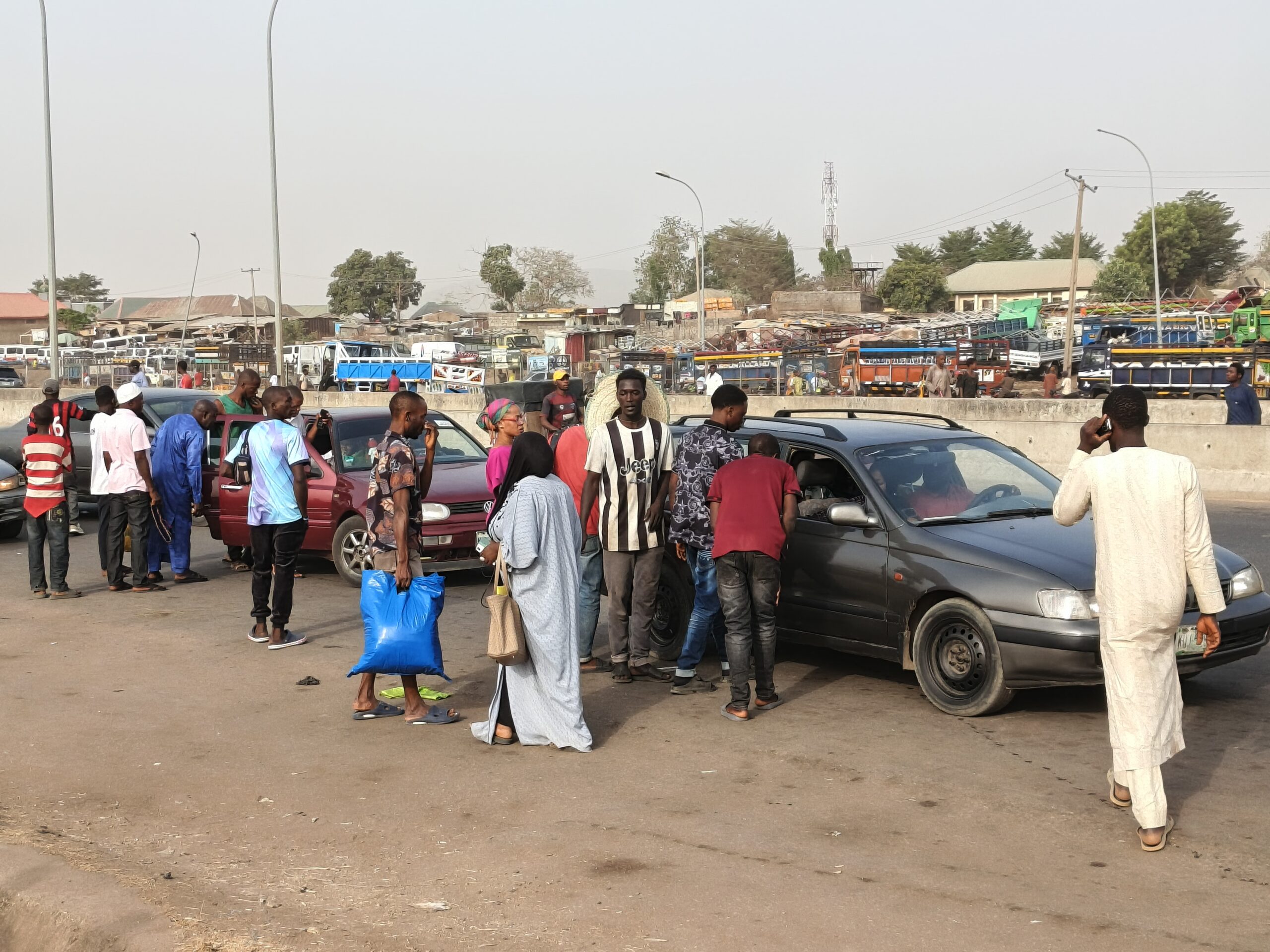 Työmatkalaiset odottavat takseja Abujassa Nigeriassa, missä monet asukkaat ovat joutuneet one chance -ryöstöjen uhreiksi. Rikolliset tekeytyvät kuljettajiksi tai matkustajiksi ja ryöstävät uhrit ajoneuvon ollessa liikkeessä. Kuva: Promise Eze/IPS.