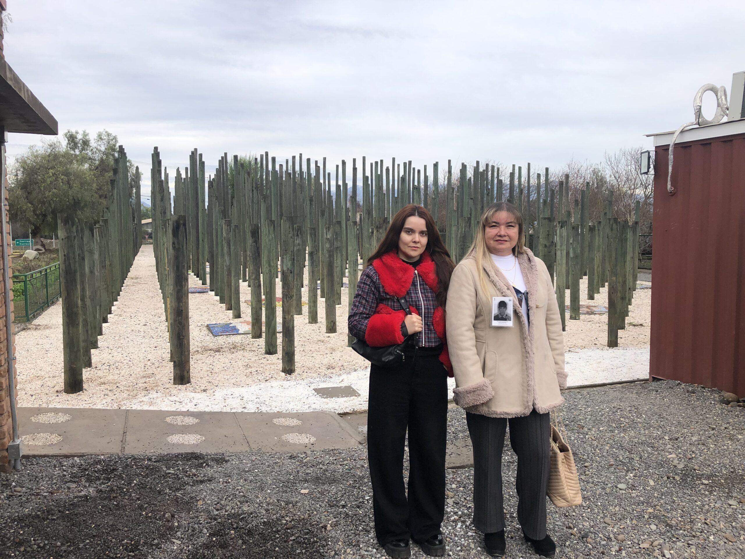 Corporación Memorial Paine -järjestön johtajat Amparo Gaete ja Myriam Sepúlveda seisovat mosaiikkien ja puuveistoksen edessä. Muistomerkki on omistettu 70 maanviljelijälle, jotka pidätettiin ja katosivat Painessa sotilasvallankaappauksen jälkeen. Kuva: Orlando Milesi/IPS