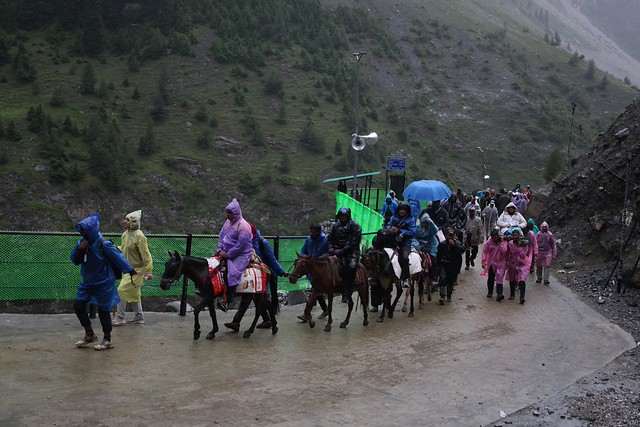 Pyhiinvaeltajia hevosmiesten ja kantajien saattamina matkaansa Baltalin reitillä vuotuisen Amarnath Yatra -pyhiinvaelluksen aikana Jammussa ja Kashmirissa heinäkuussa 2026. Kuva: Umar Manzoor Shah/IPS