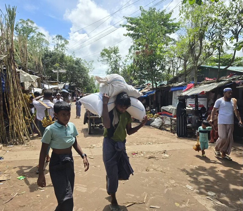 Pakolainen kantaa perheensä ruoka-annosta WFP:n jakelupisteestä suojaansa Balukhalissa Bangladeshissa. Kuva: Mohammed Zonaid/IPS